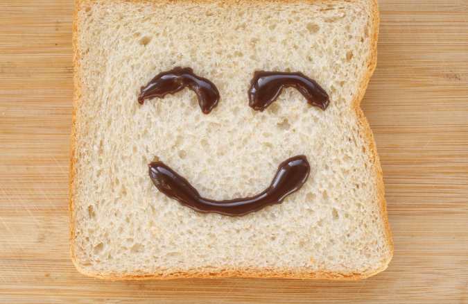 Image of a toast with a smiley face created with syrup.