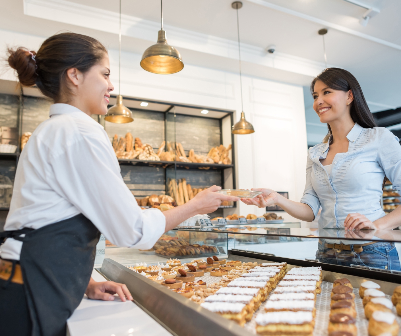 Picture of a person getting served their food in a bakery.