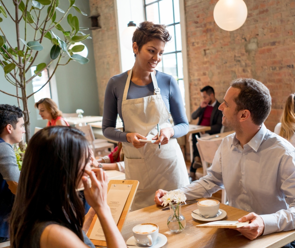 image depicting a waitress taking an order from a table of a restaurant