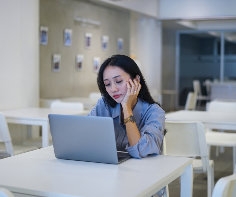 image showing a woman looking at a laptop screen with an insecure, unconvinced expression